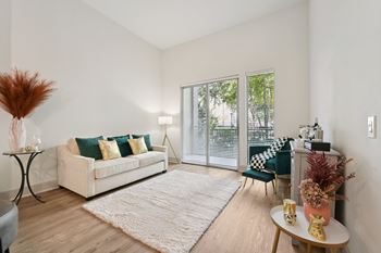 A living room with a white couch and a large window.